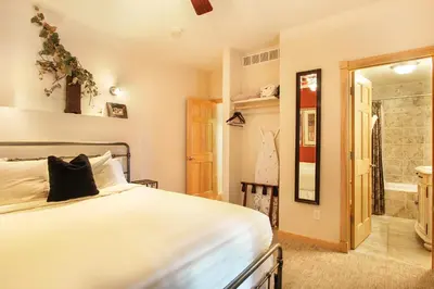 a bedroom with a bed and a walk in shower at Lookout Mountain 27B Condo in Estes Park