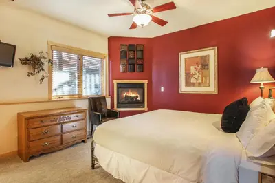 a red bedroom with a bed and a fireplace at Lookout Mountain 27B Condo in Estes Park
