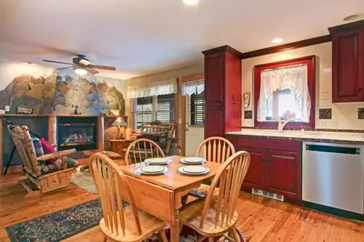 a kitchen and dining room with a table and a fireplace at Snowdrift Peak 203 Condo in Estes Park