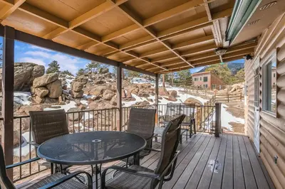 a patio with a table and chairs on a deck at Starlight In The Rockies in Estes Park