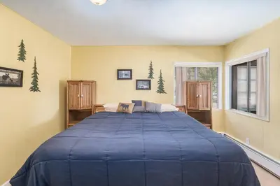a bedroom with a large bed with blue sheets at Starlight In The Rockies in Estes Park