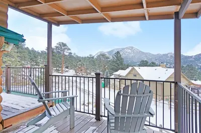 a balcony with two chairs and a view of the mountains at Starlight In The Rockies in Estes Park
