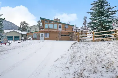 a house in the snow with a fence at Starlight In The Rockies in Estes Park