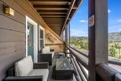 a balcony with chairs and a table on a building at Hallett Peak 101 Condo in Estes Park