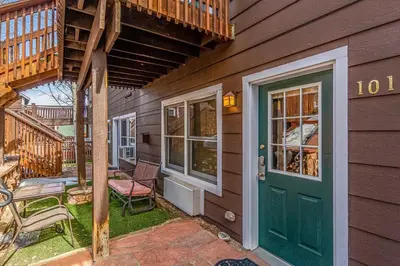 a house with a green door and a patio at Hallett Peak 101 Condo in Estes Park