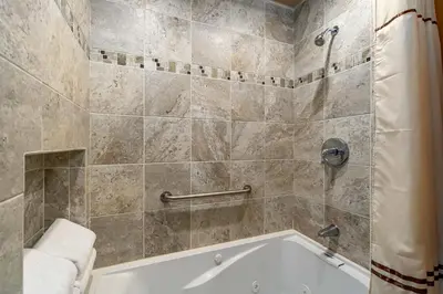 a bathroom with a tub and a shower stall at Hallett Peak 101 Condo in Estes Park