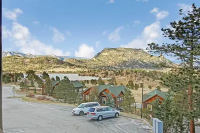 a parking lot with cars parked in front of a mountain at Hallett Peak 101 Condo in Estes Park