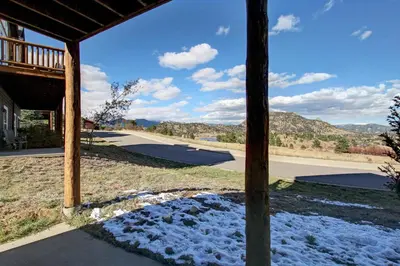 a view from the porch of a house with snow at Nisa Mountain 36 Condo in Estes Park
