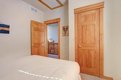 a bedroom with a bed and a wooden door at Nisa Mountain 36 Condo in Estes Park