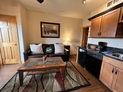 a living room with a couch and a table at Macgregor Mountain 27C Condo in Estes Park