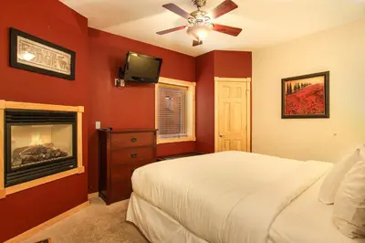a red bedroom with a bed and a fireplace at Macgregor Mountain 27C Condo in Estes Park