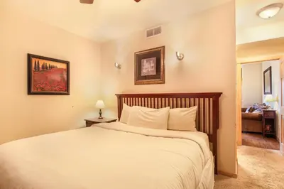 a bedroom with a large bed with white sheets at Macgregor Mountain 27C Condo in Estes Park