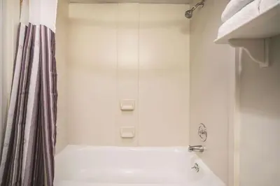 a white bathroom with a tub and a shower at La Quinta Inn by Wyndham Denver Westminster in Westminster