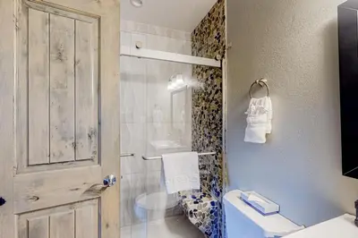 a bathroom with a toilet and a shower with a door at Mountainside D257 in Frisco