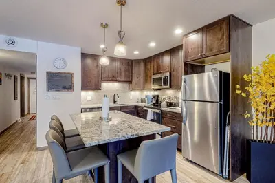 a kitchen with a table and a stainless steel refrigerator at Mountainside D257 in Frisco