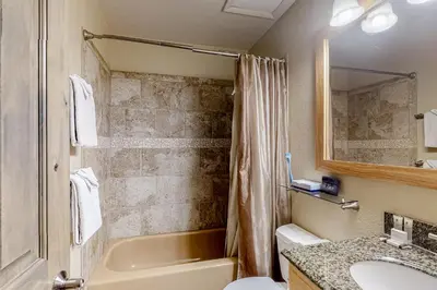 a bathroom with a tub and a toilet and a sink at Mountainside D257 in Frisco