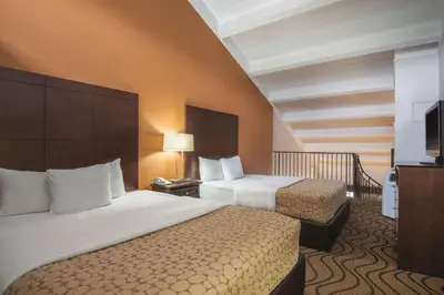 a hotel room with two beds and a television at Mountain Valley Inn & Suites in Silverthorne