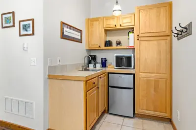 a small kitchen with wooden cabinets and a sink at Mountain Shadows Resort in Estes Park