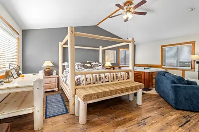 a bedroom with a wooden bed and a blue couch at Mountain Shadows Resort in Estes Park