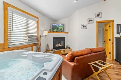 a living room with a hot tub and a couch at Mountain Shadows Resort in Estes Park