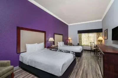 a hotel room with two beds and a purple wall at La Quinta Inn & Suites by Wyndham Loveland Estes Park in Loveland