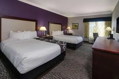 two beds in a hotel room with purple walls at La Quinta Inn & Suites by Wyndham Loveland Estes Park in Loveland