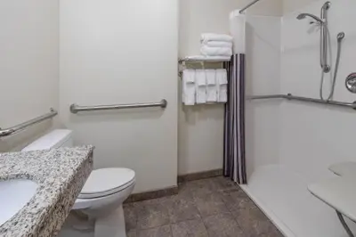 a bathroom with a toilet and a shower and a sink at La Quinta Inn & Suites by Wyndham Loveland Estes Park in Loveland