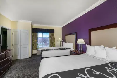 a hotel room with two beds and a purple wall at La Quinta Inn & Suites by Wyndham Loveland Estes Park in Loveland