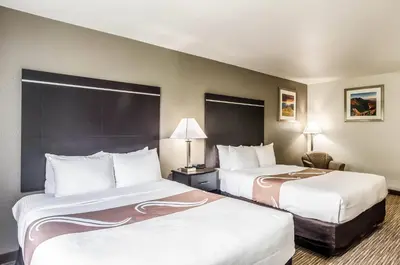 a hotel room with two beds and a chair at Quality Inn & Suites Westminster - Broomfield in Westminster