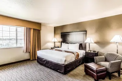 a hotel room with a bed and a chair at Quality Inn & Suites Westminster - Broomfield in Westminster
