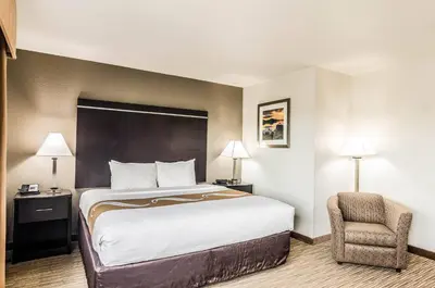 a hotel room with a bed and a chair at Quality Inn & Suites Westminster - Broomfield in Westminster