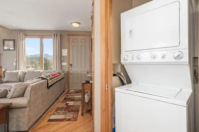 a living room with a couch and a white refrigerator at Mount Cirrus 10B Condo in Estes Park