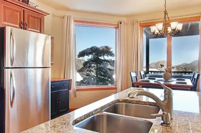 a kitchen with a stainless steel refrigerator and a window at Mount Cirrus 10B Condo in Estes Park
