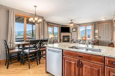 a kitchen with a sink and a table with chairs at Mount Cirrus 10B Condo in Estes Park
