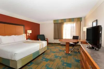 a hotel room with a bed and a desk and a television at La Quinta by Wyndham Denver Southwest Lakewood in Lakewood