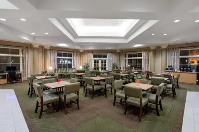 a dining room with tables and chairs and windows at La Quinta by Wyndham Denver Southwest Lakewood in Lakewood