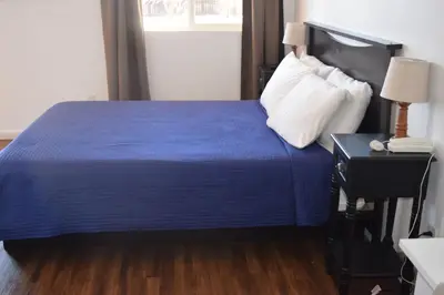 a bedroom with a blue bed and a phone on a table at Stone Mountain Lodge in Lyons