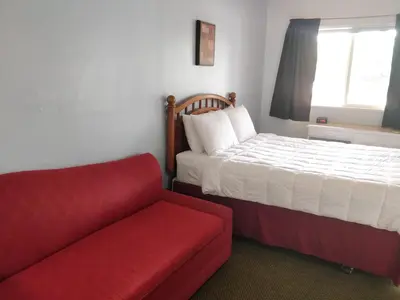a bedroom with a bed and a red couch at Stone Mountain Lodge in Lyons