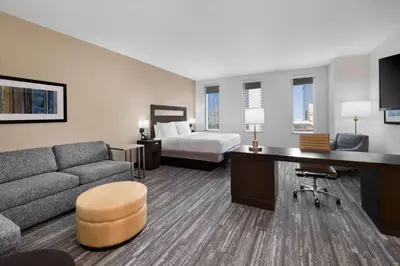 a hotel room with a couch and a bed at Hampton Inn & Suites Denver Downtown Convention Center in Denver