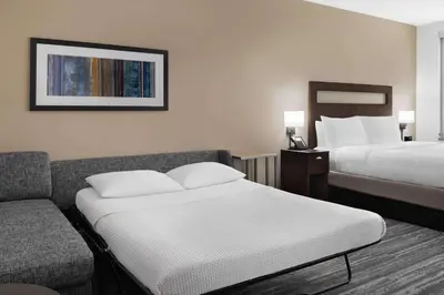 a hotel room with two beds and a couch at Hampton Inn & Suites Denver Downtown Convention Center in Denver
