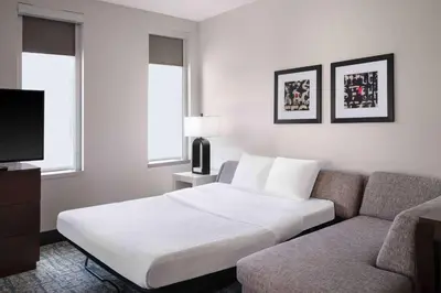 a hotel room with a bed and a couch at Homewood Suites- Denver Downtown Convention Center in Denver