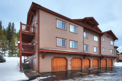 a large wooden house with a wooden garage at Swans Nest Villa 1601 Condo in Breckenridge