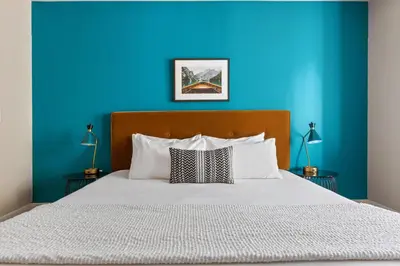 a bedroom with a blue wall and a bed at Kasa Union Station Denver in Denver