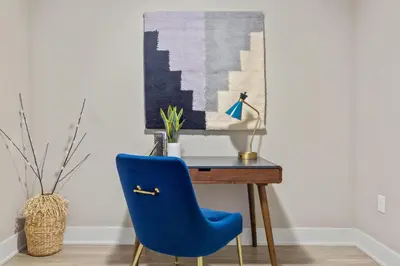 a blue chair sitting in front of a desk at Kasa Union Station Denver in Denver