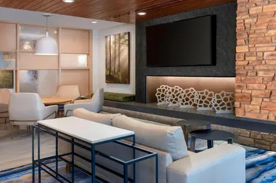 a waiting room with a tv on a brick wall at Fairfield Inn & Suites by Marriott Denver Tech Center North in Denver