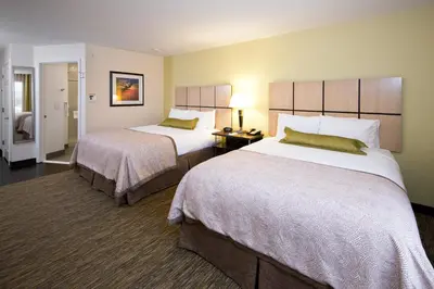 a hotel room with two large beds and a room at Candlewood Suites Greeley by IHG in Greeley