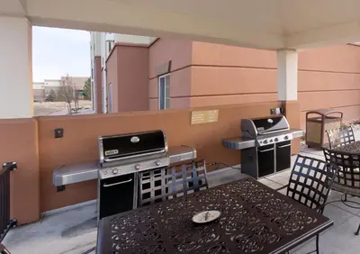a outdoor kitchen with two stoves and a table at Candlewood Suites Greeley by IHG in Greeley