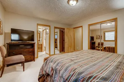 a bedroom with a bed and a flat screen tv at Casa de Montagne Home: High-End Log Home, Downtown Frisco in Frisco