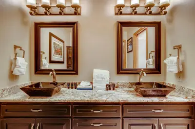 two sinks in a bathroom with two mirrors at Casa de Montagne Home: High-End Log Home, Downtown Frisco in Frisco