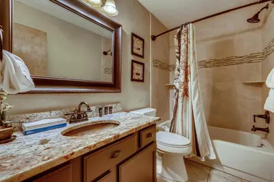 a bathroom with a sink and a toilet and a mirror at Casa de Montagne Home: High-End Log Home, Downtown Frisco in Frisco